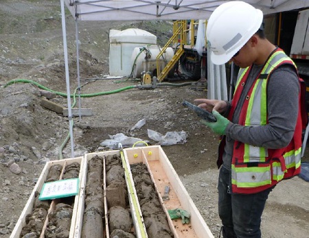 KCB employee logging drill holes using a hand-held rugged device.